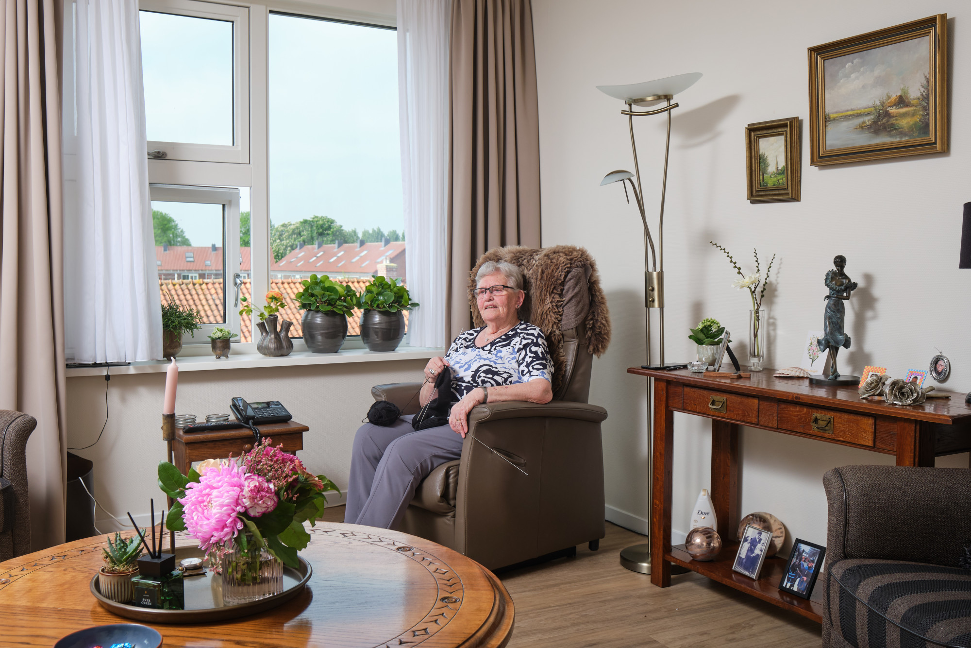 client zit in haar woonkamer in de stoel