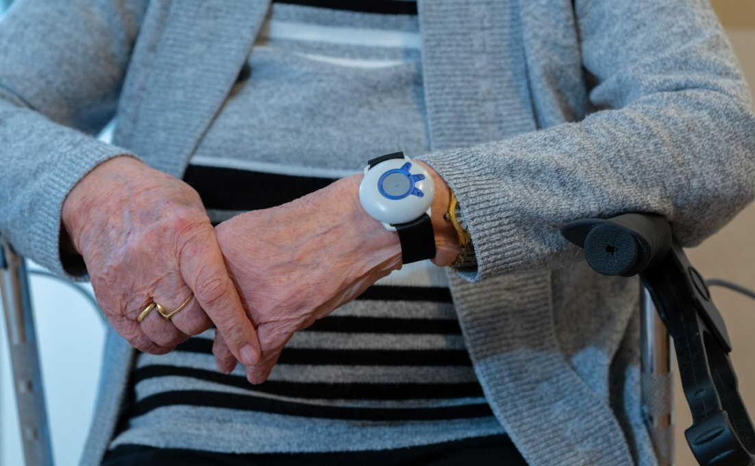 mevrouw met gps tracker om pols