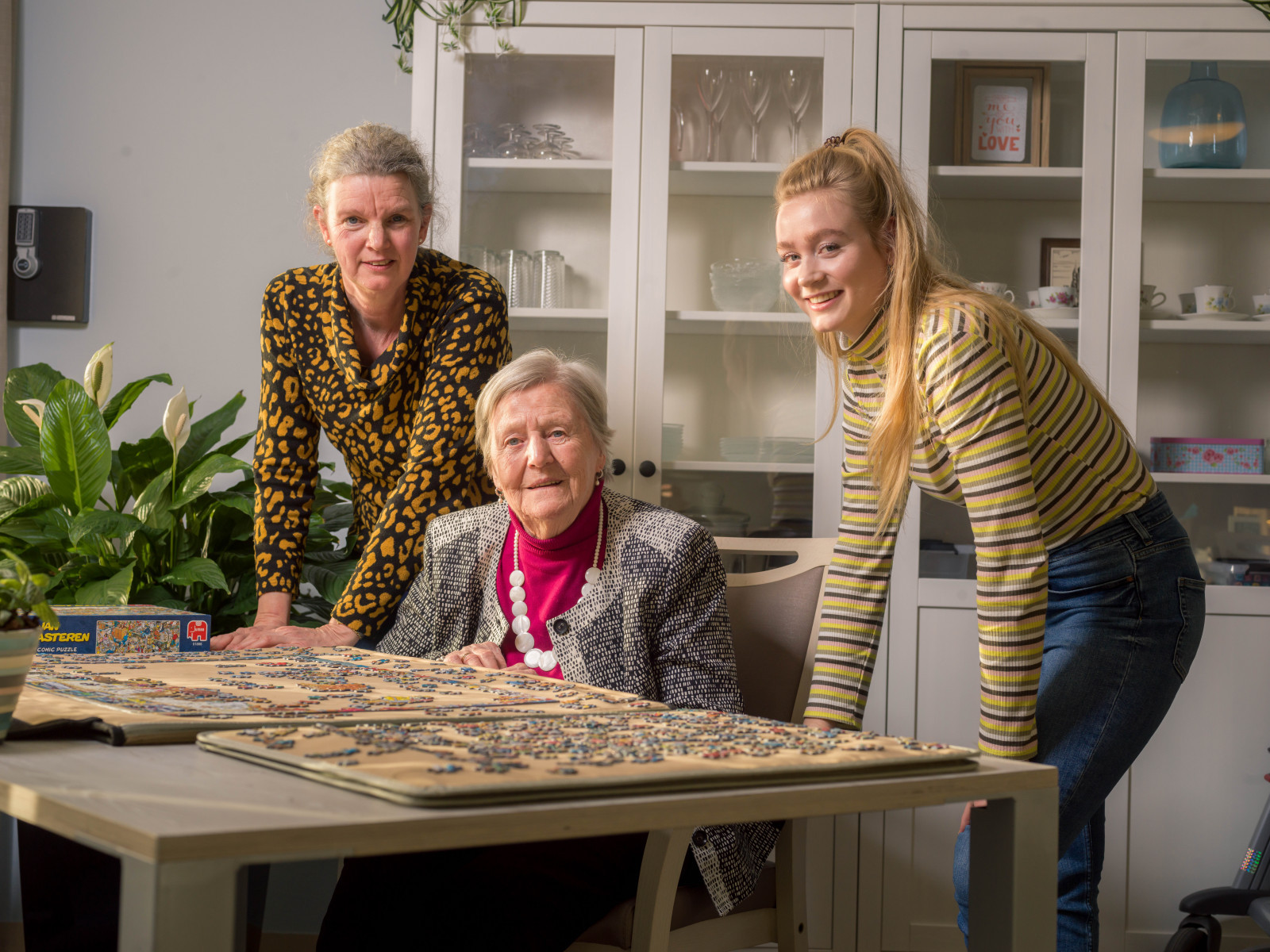 Twee verzorgenden maken een puzzel met cliënt