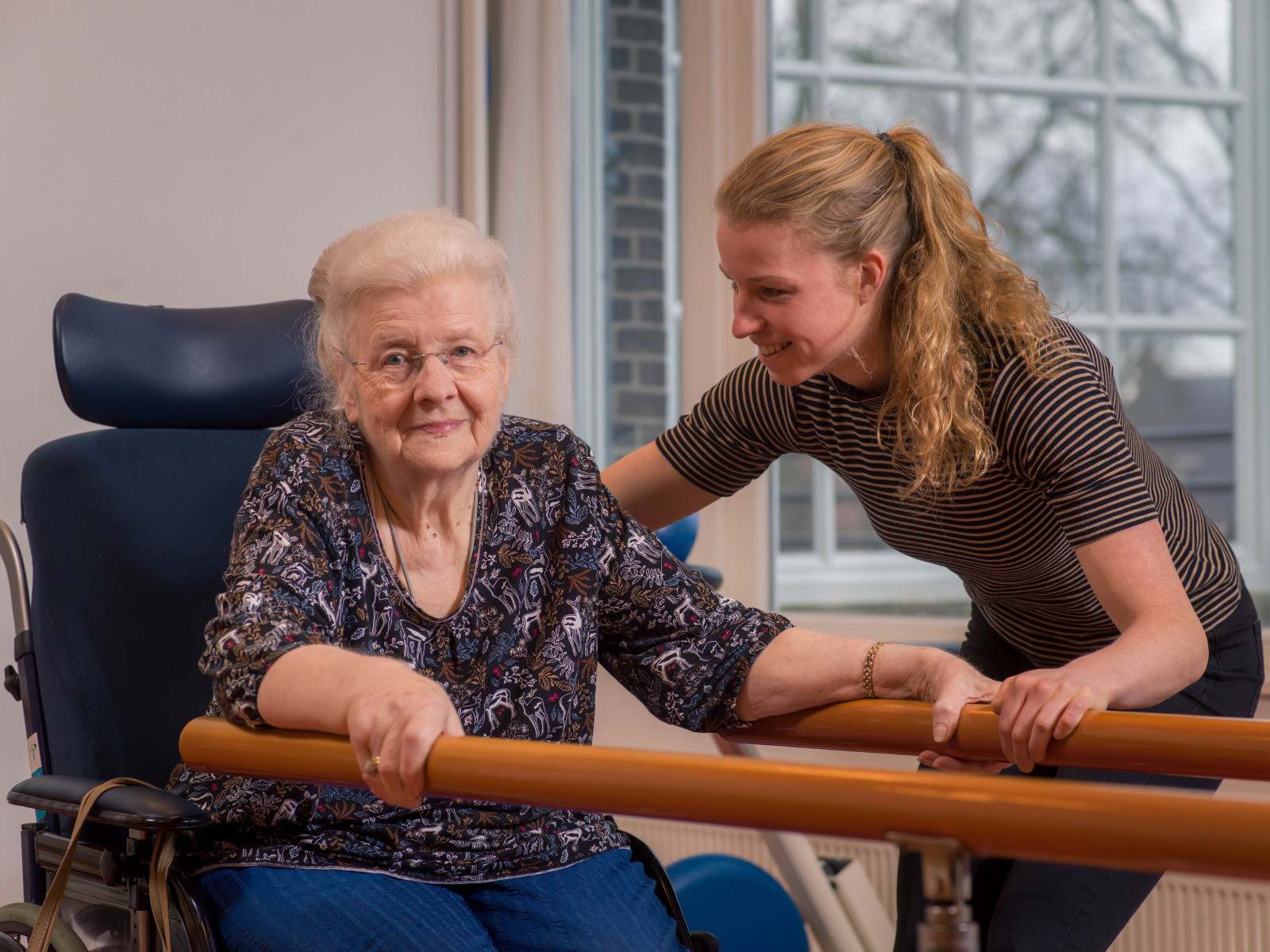 Fysiotherapeut helpt cliënt bij loopbrug